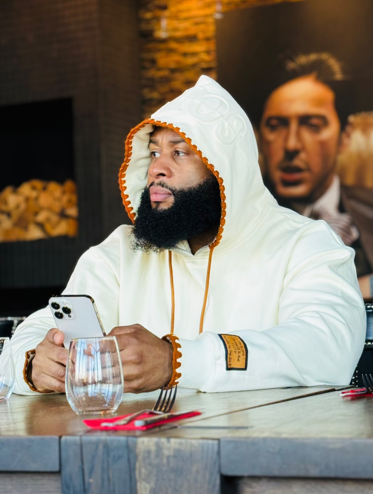 Seated with the hood up — crochet trim and leather label detail